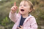 happy-little-girl-pointing-up-while-smiling-outdoors_138670-3995[1].jpg