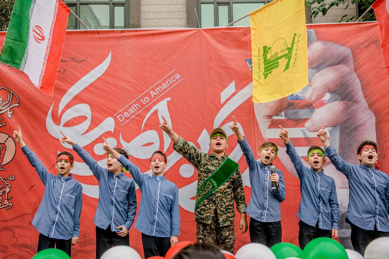 Iranian children perform on stage in front of a Death to America banner in Tehran, on Nov. 3, 2024. Photo by Hossein Beris/Middle East Images/AFP via Getty Images.